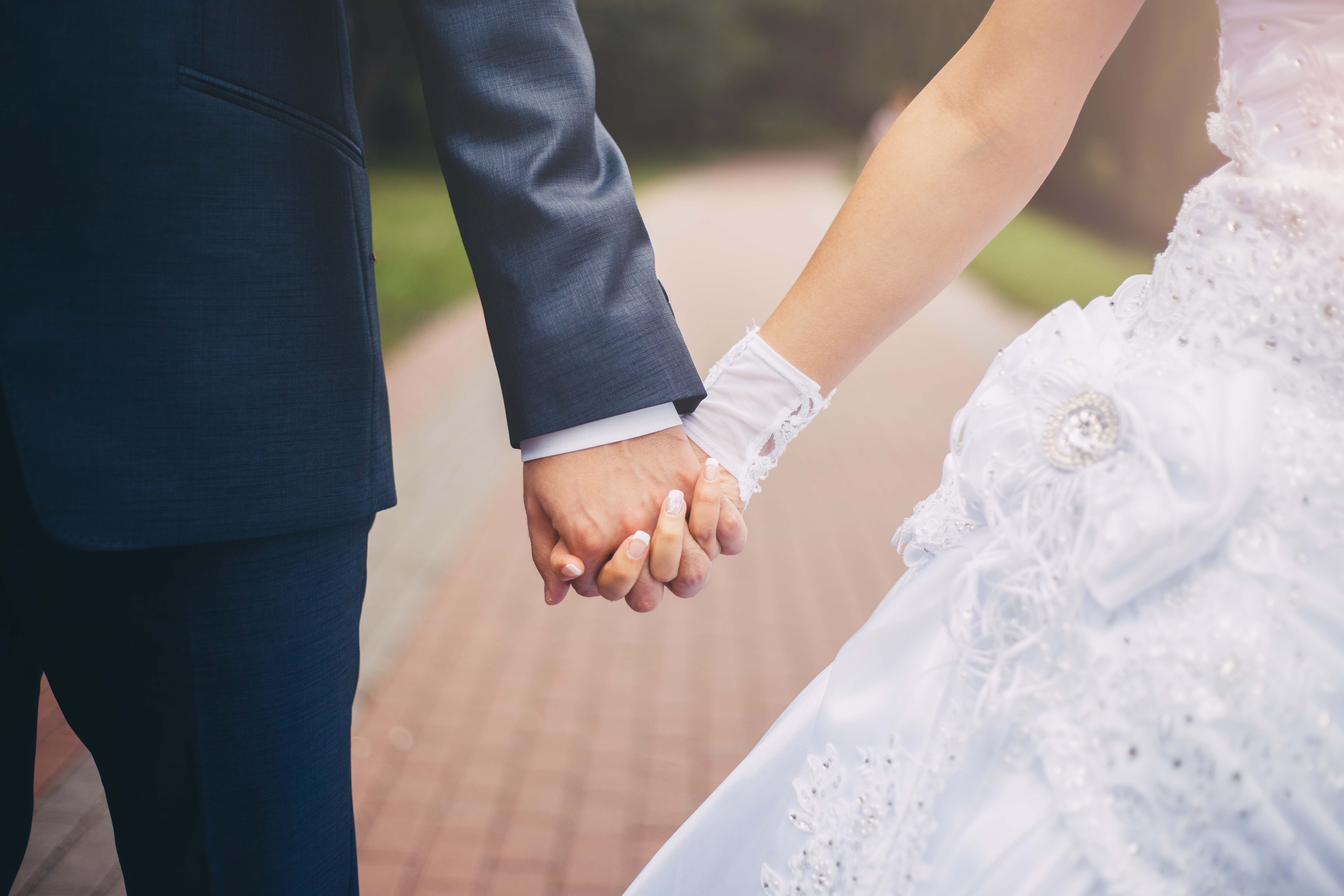 Брак вдовцов. Жених и невеста держатся за руки. Брак свадьба. Молодожены. Невеста на руках у жениха.